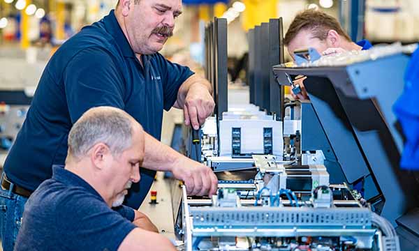 BlueCrest technicians perform maintenance, repairs, and testing on mail inserting machines