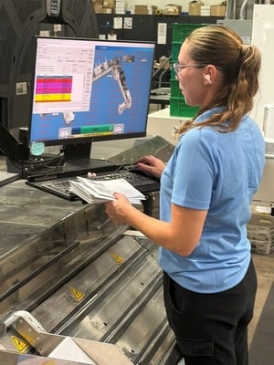 Renkim employee operating a BlueCrest Epic inserter